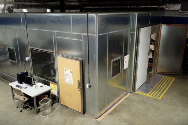 Completed, custom-built radio frequency (RF) shielding enclosure with exterior control desk and sealed access doors in a facility.
