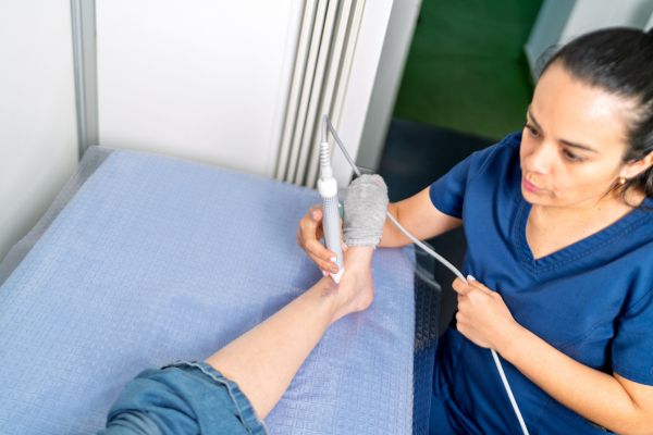 Medical professional performing a diagnostic ultrasound on a patient's foot and ankle.