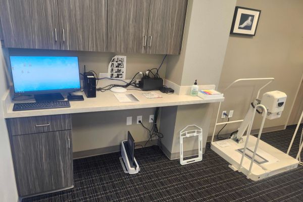 Professional podiatrist exam room with standing X-ray equipment for foot and ankle imaging.